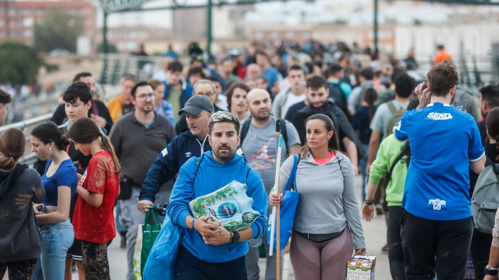 Miles de personas, cargadas con escobas, palas y comida, llegan a pie a las zonas afectadas por la DANA en Valencia