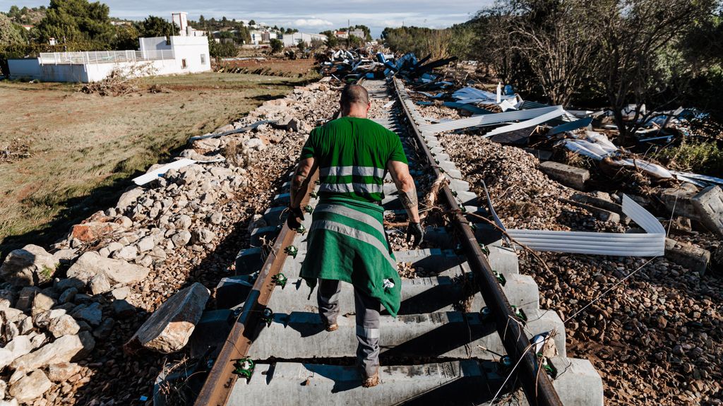 Un hombre camina por unas vías de tren buscando víctimas en una zona afectada por la DANA