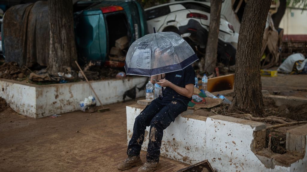 Un hombre se protege de la lluvia en Benetússer, Valencia