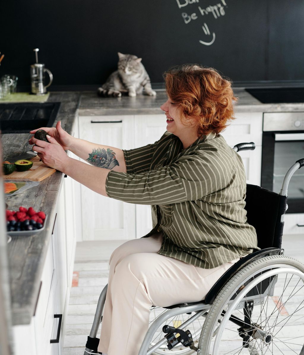 Una mujer en silla de ruedas, cocinando.