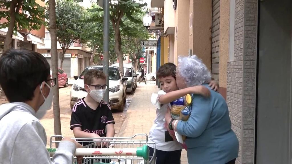 Un grupo de niños voluntarios reparten comida a los afectados por la DANA.