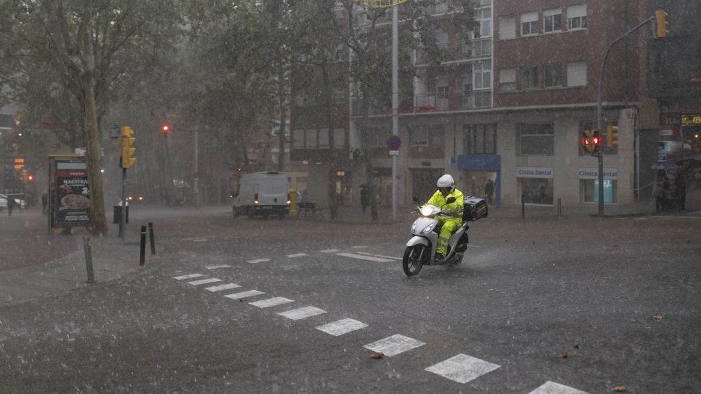 Un repartidor en moto durante la tormenta, a 30 de octubre de 2024, en Barcelona, Catalunya