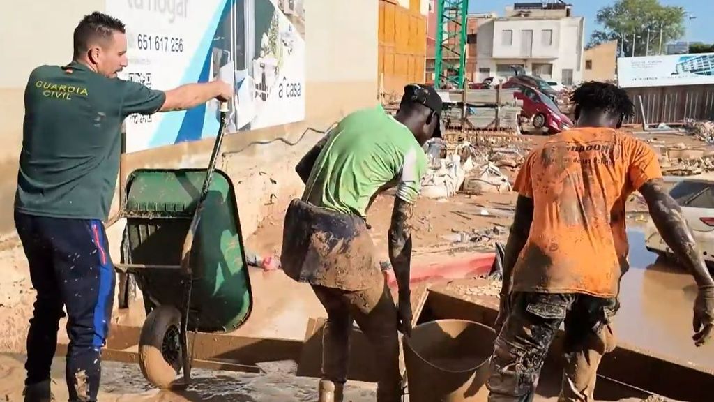 Manteros y temporeros ayudan a la Guardia Civil a limpiar un garaje en Alfafar, Valencia