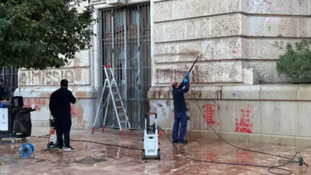 Operarios limpian las fachadas del Ayuntamiento y el Palau de la Generalitat