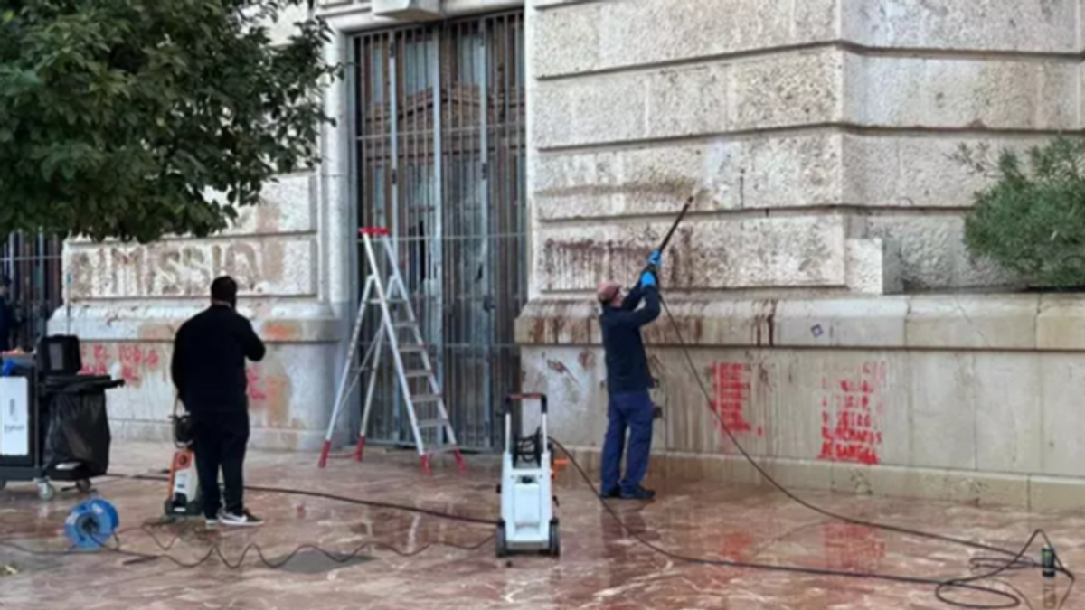 Operarios limpian las fachadas del Ayuntamiento y el Palau de la Generalitat