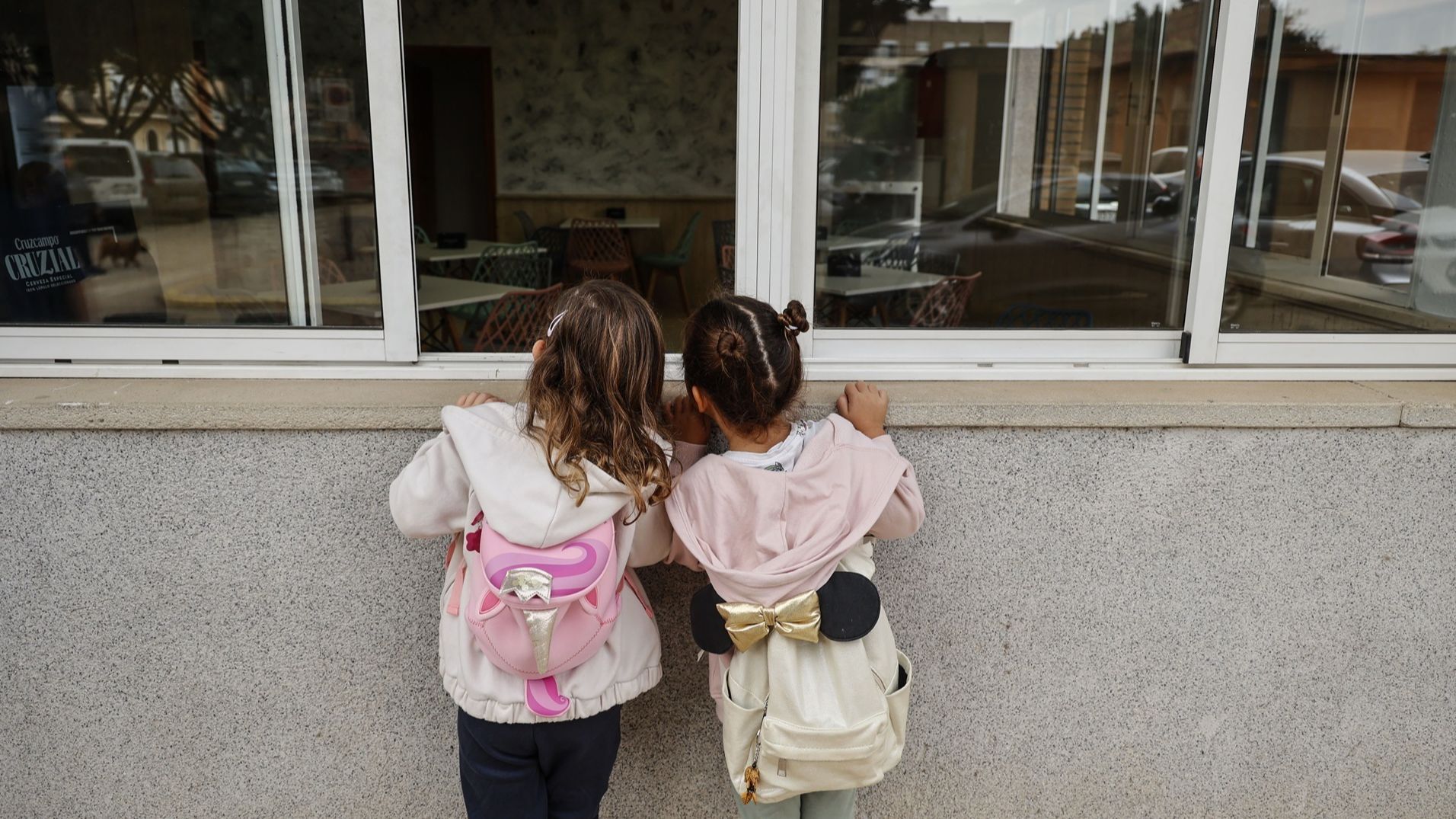 Dos niñas observan el interior vacío del colegio CEIP Amparo Alabau en Alaquàs, Valencia