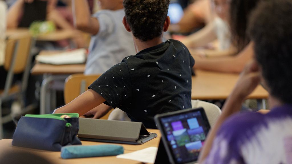 Alumnos españoles en un aula con dispositivos electrónicos