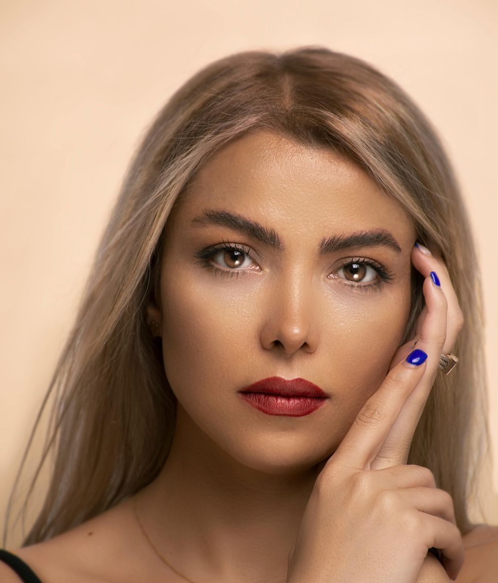 Mujer con las uñas maquilladas de azul intenso