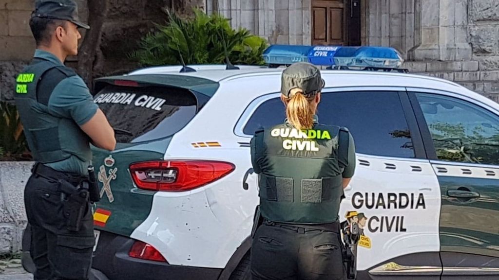 Una agente y un coche de la Guardia Civil