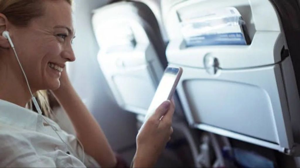 Una mujer conectada al Wi-Fi durante un vuelo