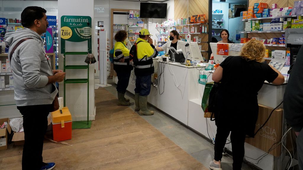 Varias personas compran medicinas en una farmacia tras el paso de la DANA por Valencia