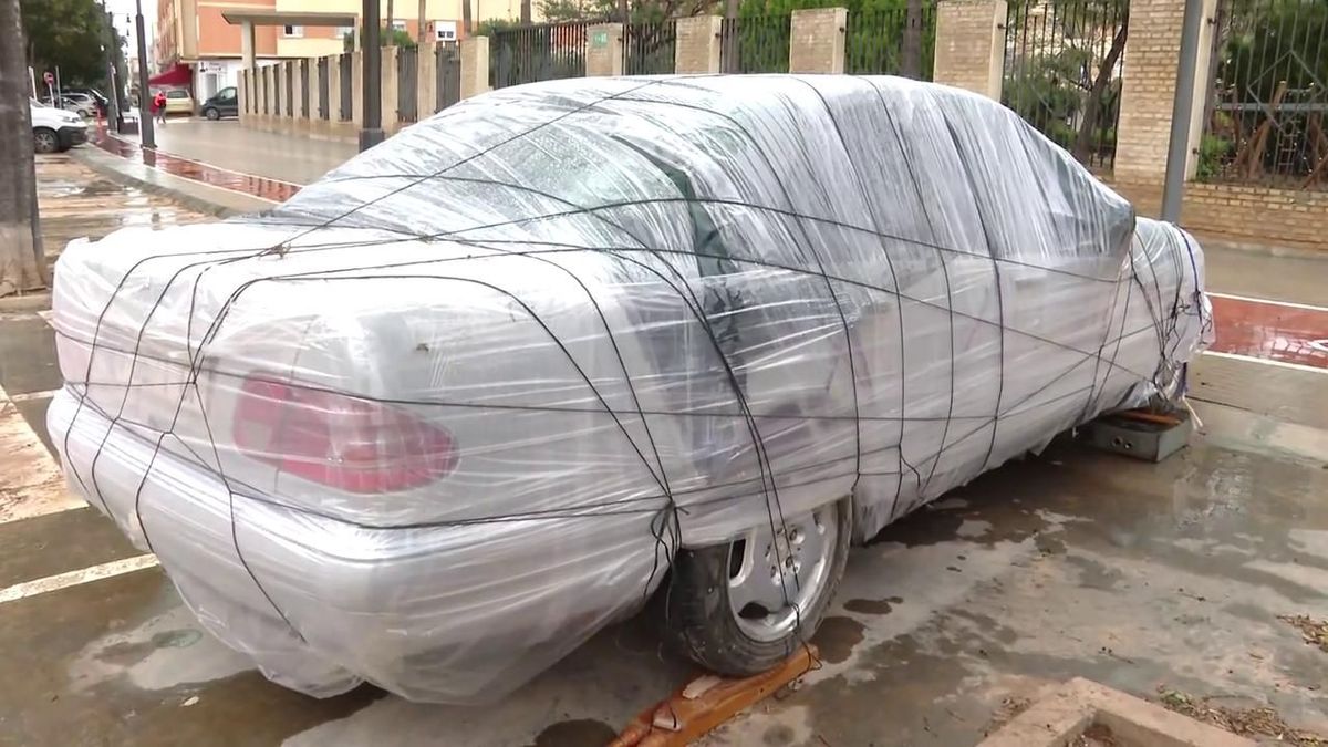 Un vecino de La Alcudia ha envuelto con plástico su coche para protegerlo de la DANA.