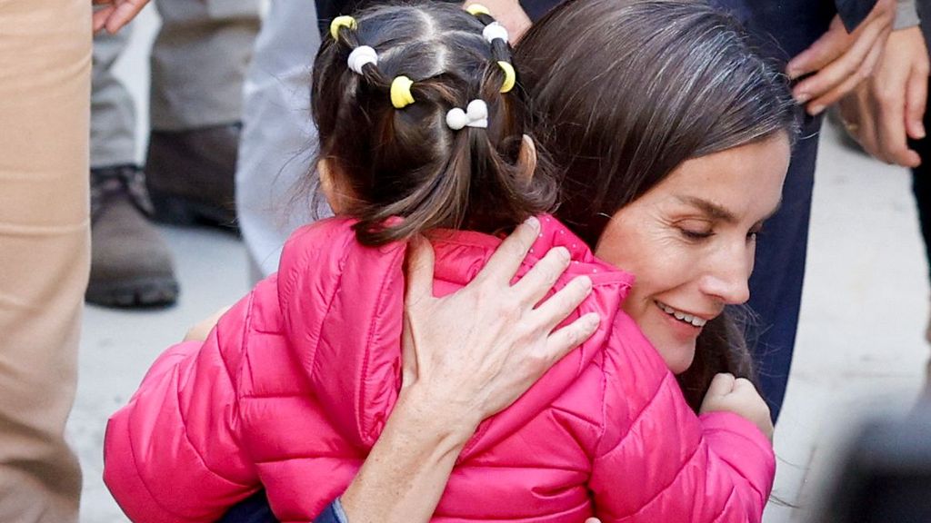 La reina Letizia abraza a una niña durante la visita de los reyes a Chiva