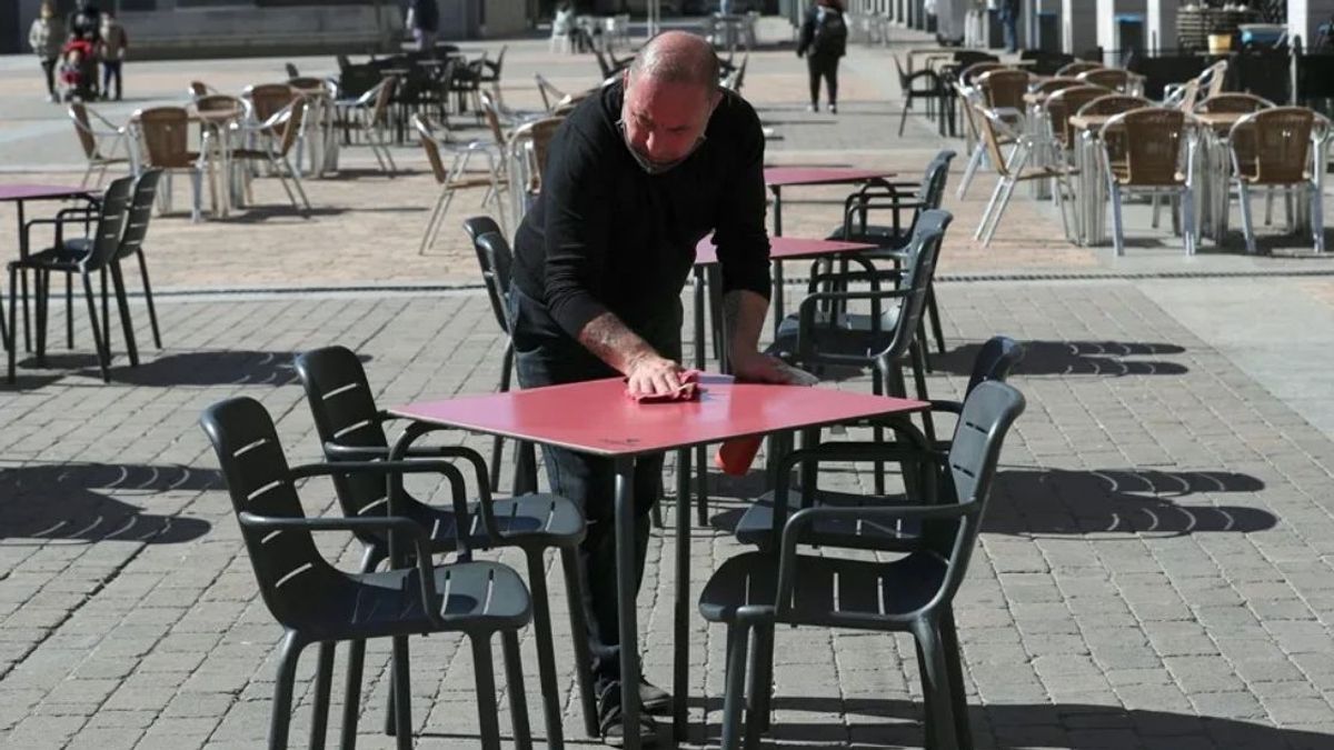 Un camarero limpia una mesa en un bar de Madrid