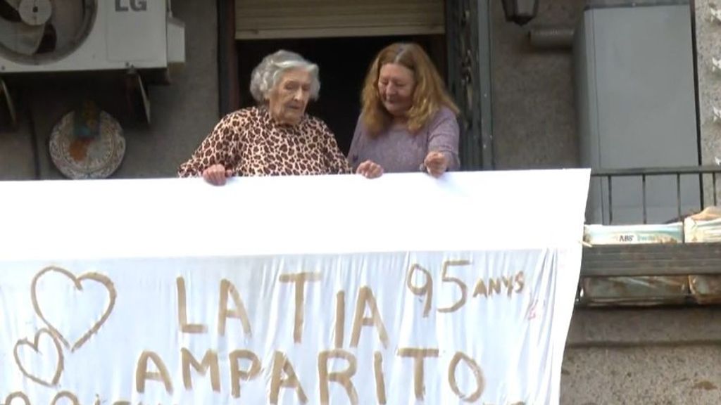 Amparito junto a su nuera con la sábana que han colgado en su balcón agradeciendo la ayuda de los voluntarios en Paiporta