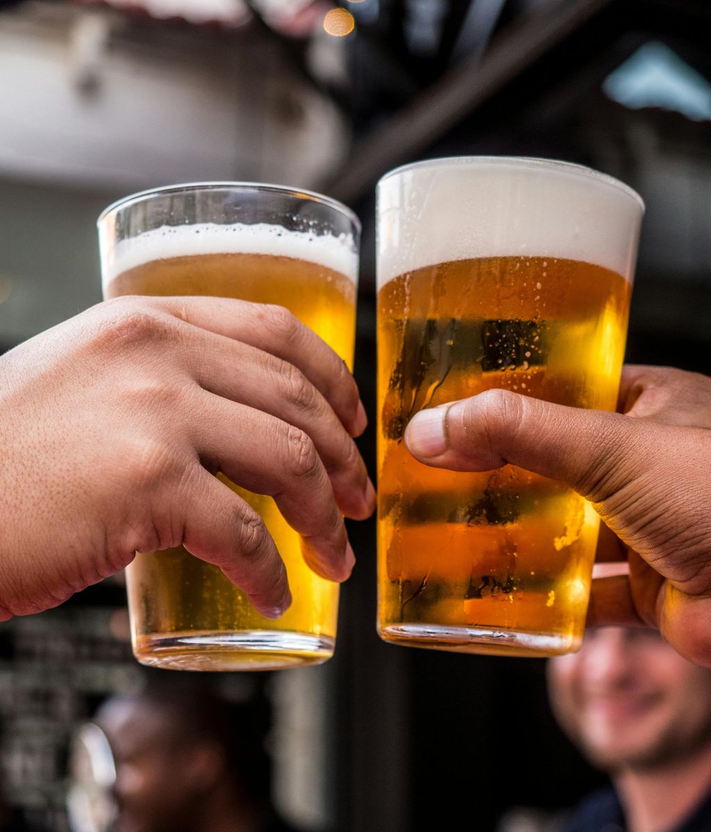 Dos personas brindan con vasos de cerveza