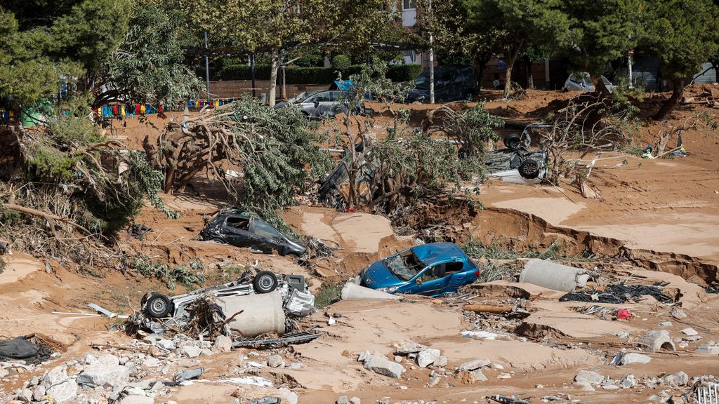 Varios vehículos permanecen semienterrados entre el lodo tras el paso de la dana, en Paiporta, Valencia