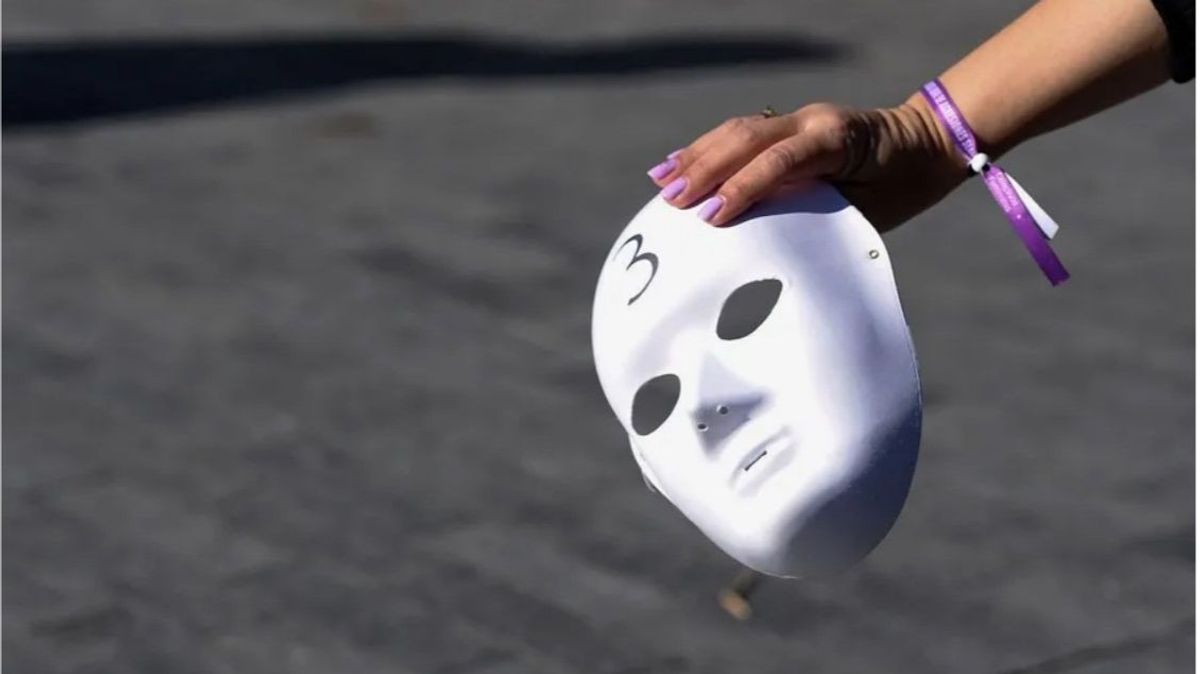 Imagen de archivo de una mujer sosteniendo una careta durante una concentración con motivo del Día Internacional para la Eliminación de la Violencia Contra las Mujeres.