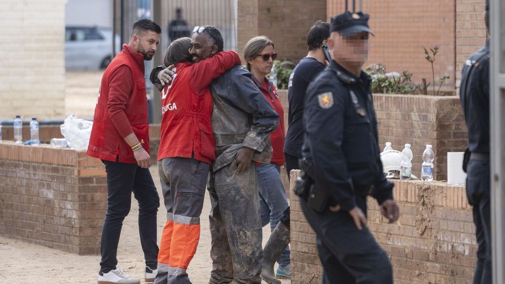 Una voluntaria de Cruz Roja abraza a un vecino en Massanassa tras la caída del porchado del colegio