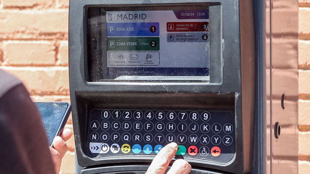 Una persona utiliza un parquímetro en Madrid.