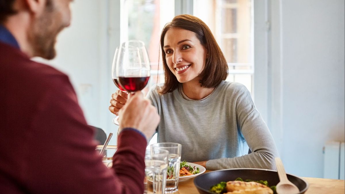 Una mujer brindando con vino