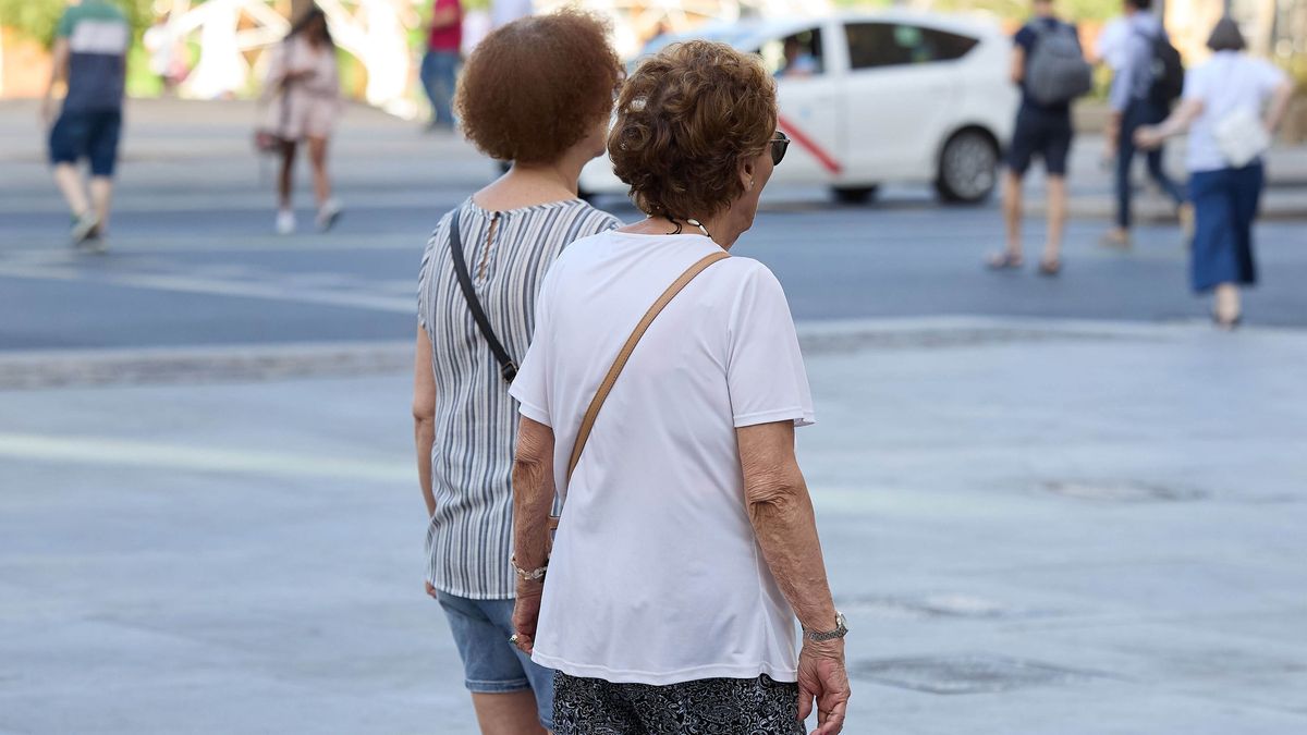 Dos señoras mayores caminan por una calle de Madrid.