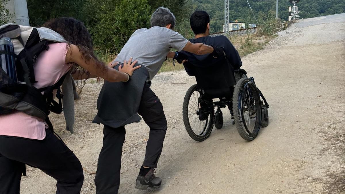 Javi Hortelano, junto a su hija, empuja la silla de ruedas durante el Camino de Santiago