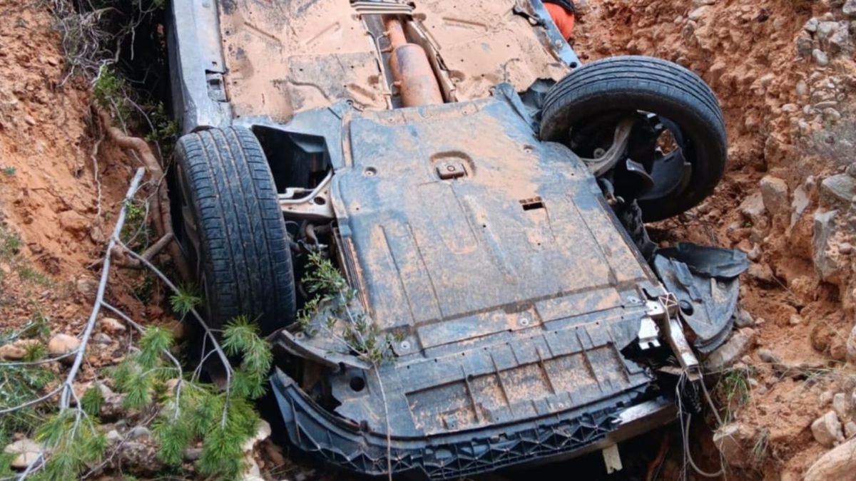 El coche quedó volcado tras la caída por el barranco en Valencia.