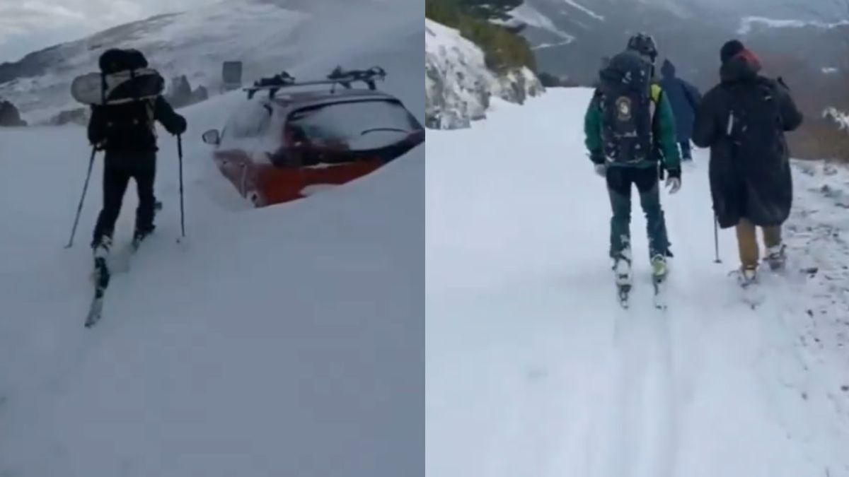 Los agentes rescatando a los dos pasajeros de un coche atrapados por la nieve