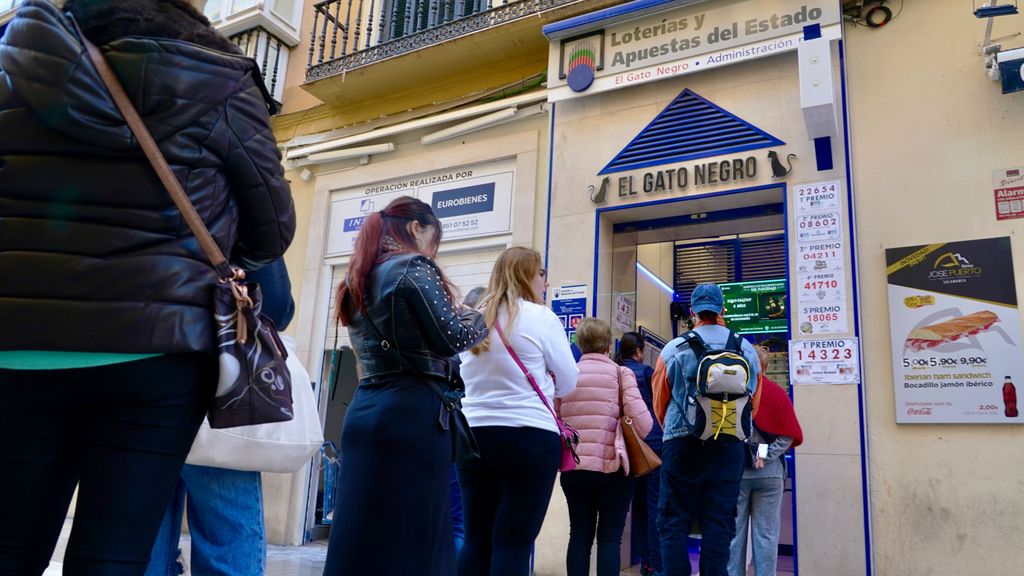 Varias personas hacen cola para adquirir décimos de la Lotería de Navidad.