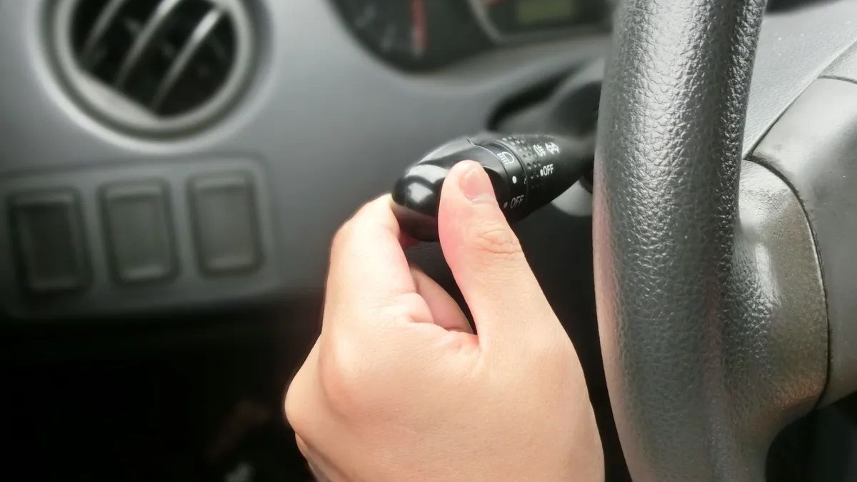 Una persona accionando los intermitentes de su vehículo