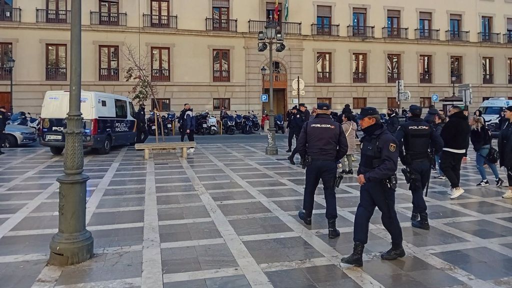 Familiares de la víctima y agentes en Plaza Nueva, a la salida del furgón policial donde iba el acusado de matar a un hombre en Churriana de la Vega (Granada)