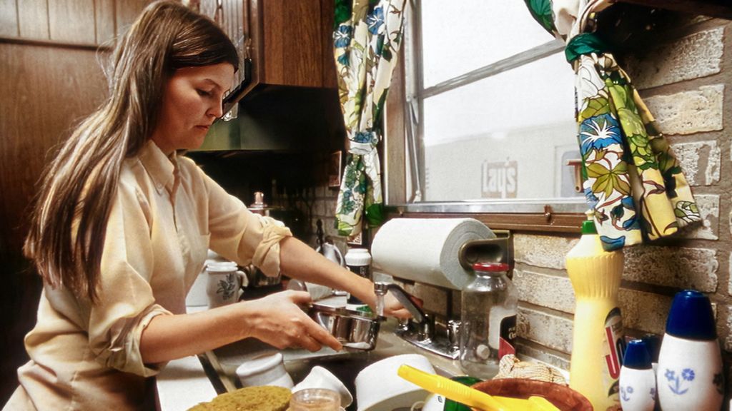 Una mujer realizando labores de limpieza en la cocina. Foto de archivo.