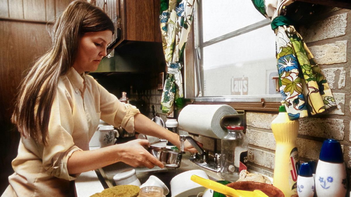 Una mujer realizando labores de limpieza en la cocina. Foto de archivo.