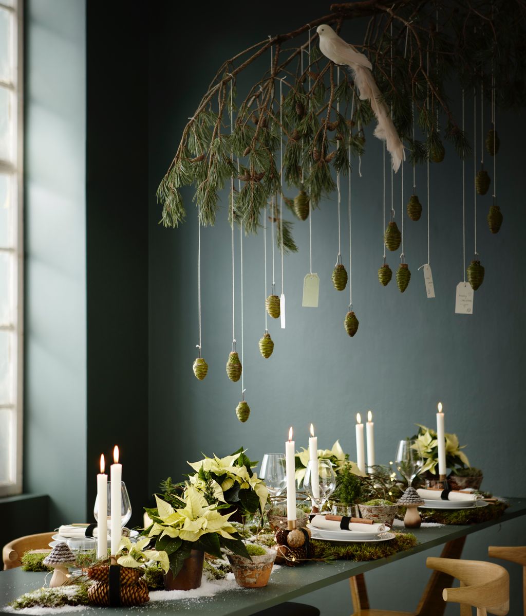 Mesa de Navidad con poinsettias amarillas y adorno de ramas en el techo