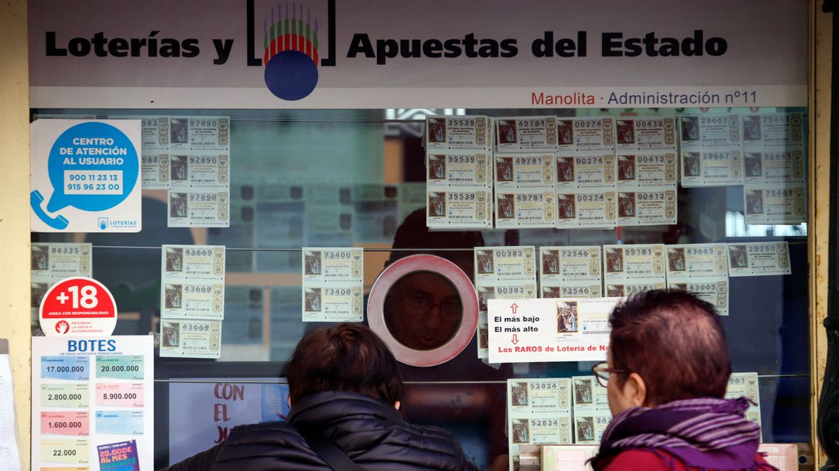 Varias personas compran décimos de lotería de Navidad en una administración de Málaga