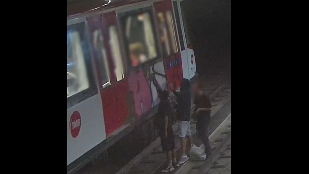 Individuos pintando el vagón de un tren con pintura