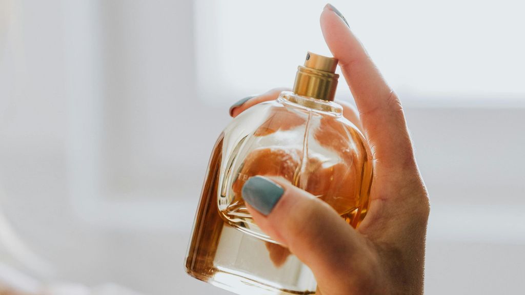 Mano de mujer perfumándose