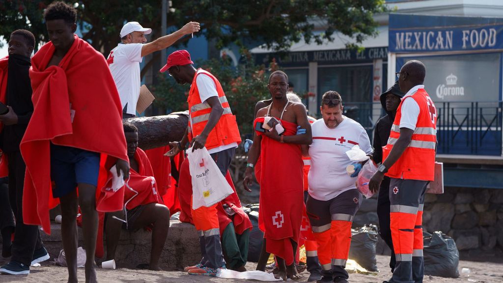 Inmigrantes son atendidos por personal de Cruz Roja tras llegar a la playa de Las Galletas, en el sur de Tenerife