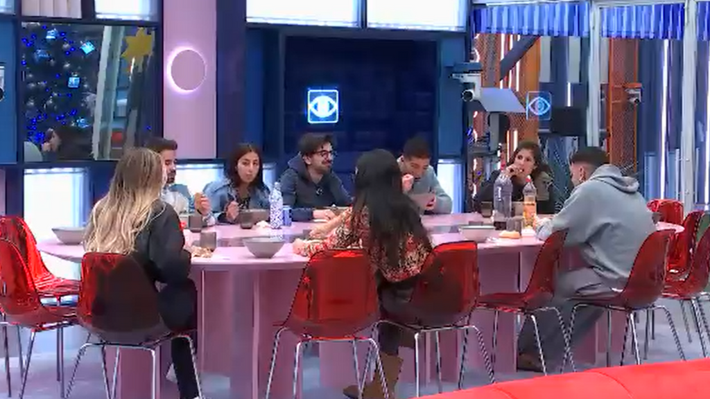 Los concursantes se van sentando a la mesa a comer