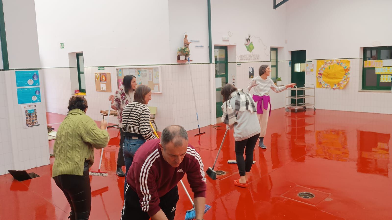 Personal del colegio Divino Maestro de Santiago, achicando el agua caída este miércoles