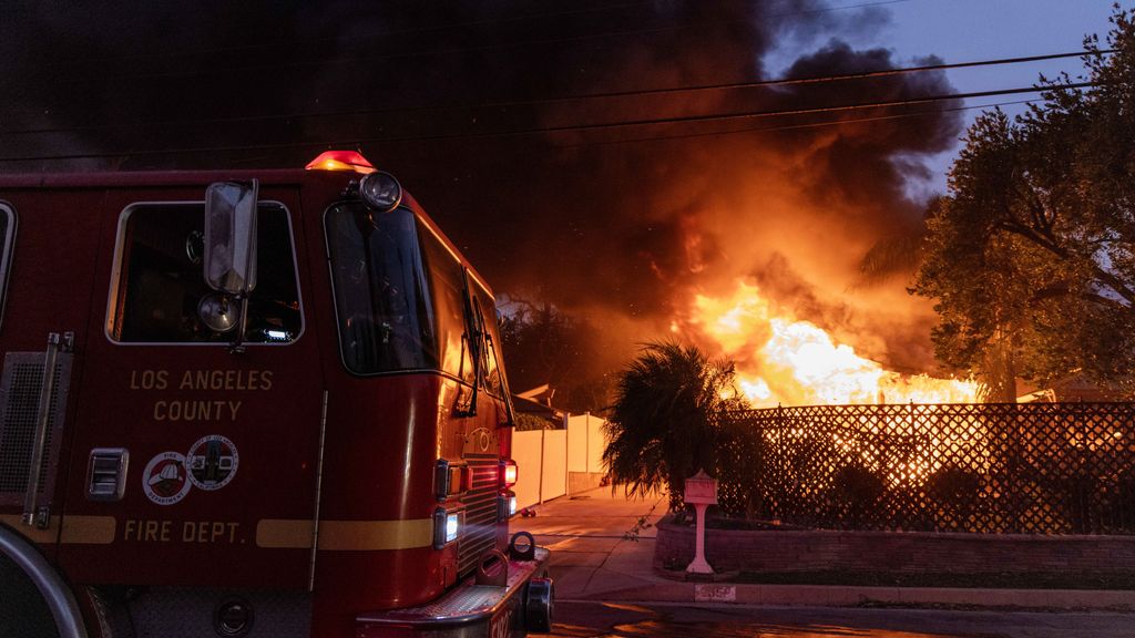 Los bomberos de Los Ángeles enfrente de una casa en llamas