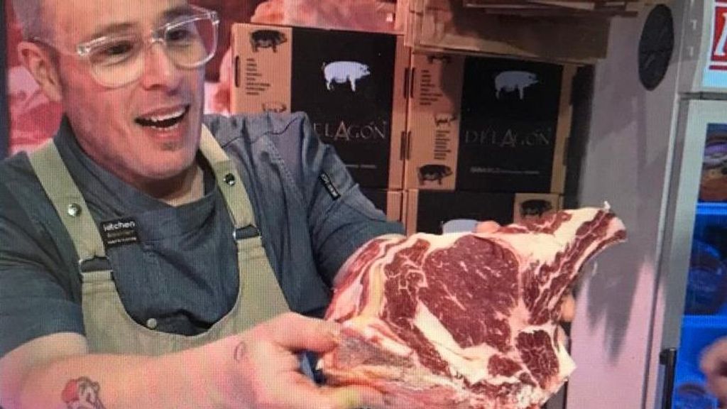 El carnicero muestra una de las chuletas, especialidad de este establecimiento de Amara