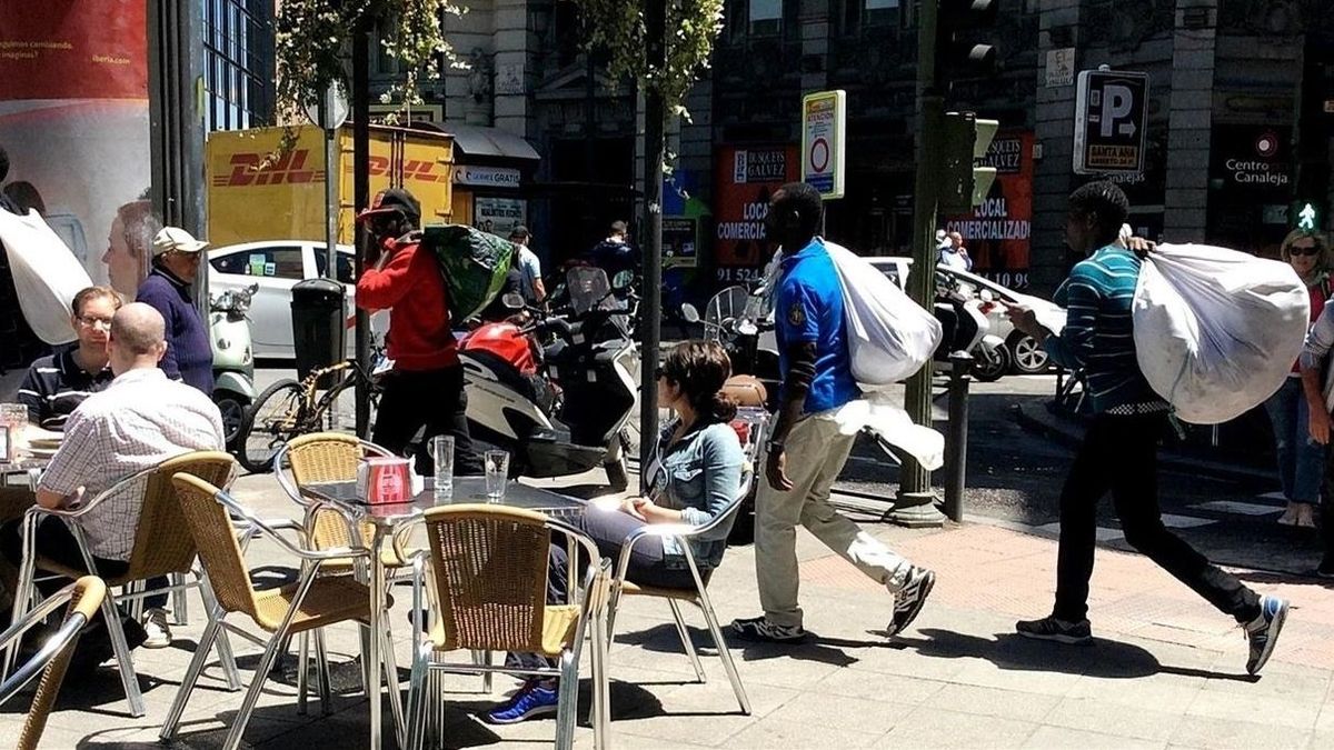 Un grupo de manteros se desplazan por una calle de Madrid