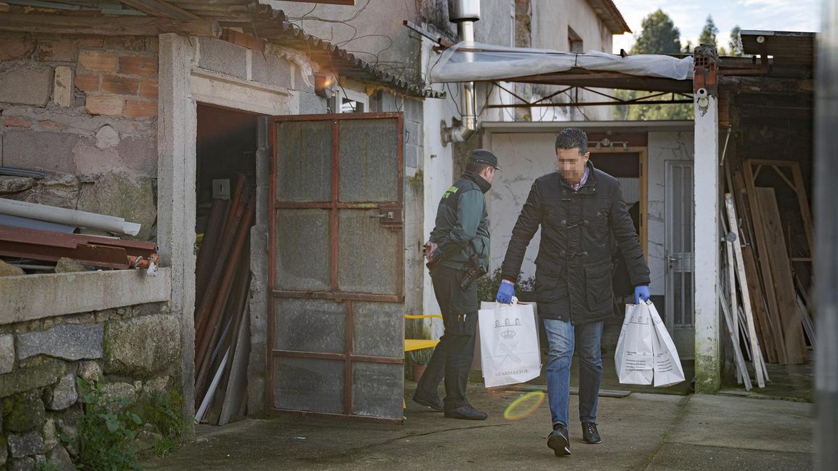 Un agente de la Guardia Civil con bolsas de pruebas de la casa donde una pareja sufrió un violento asalto, en Meis (Pontevedra)