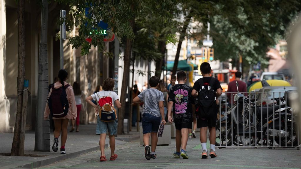 Varios niños caminan a la salida de un colegio en Barcelona