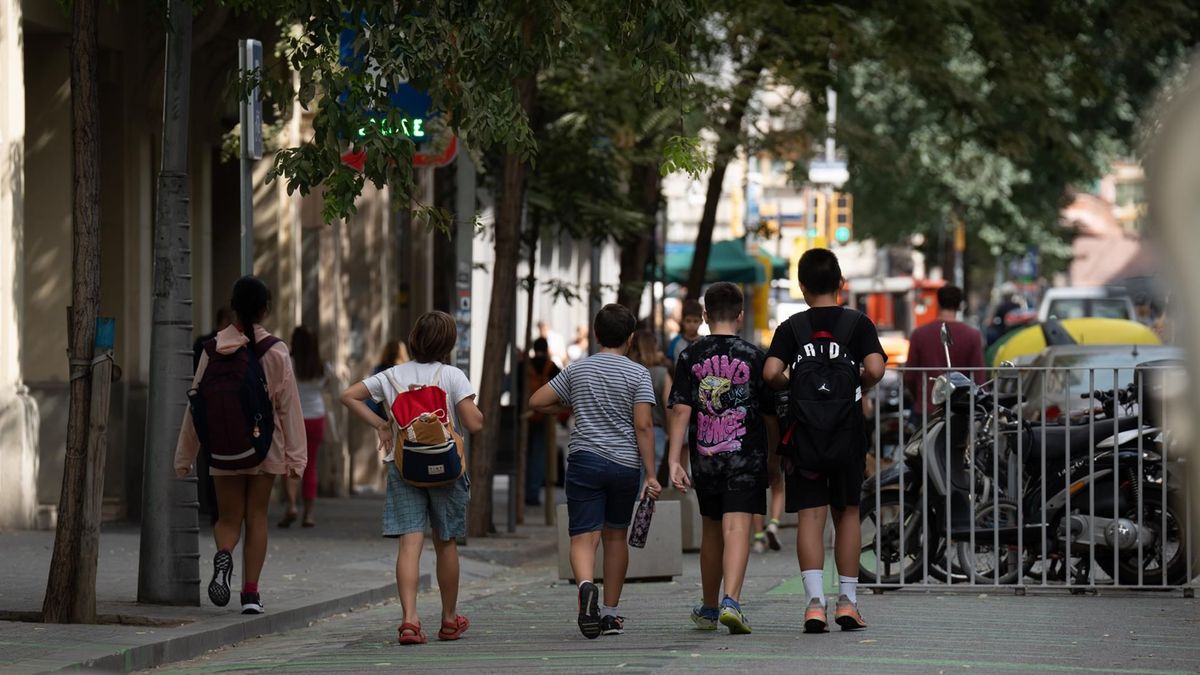 Varios niños caminan a la salida de un colegio en Barcelona