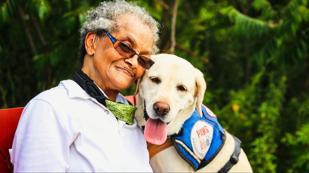 Una mujer con un perro de asistencia