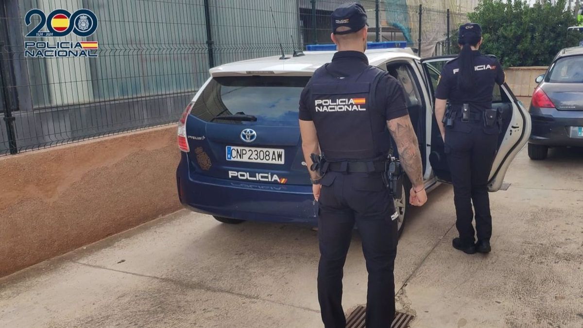 Agentes de la Policía Nacional frente a un coche patrulla