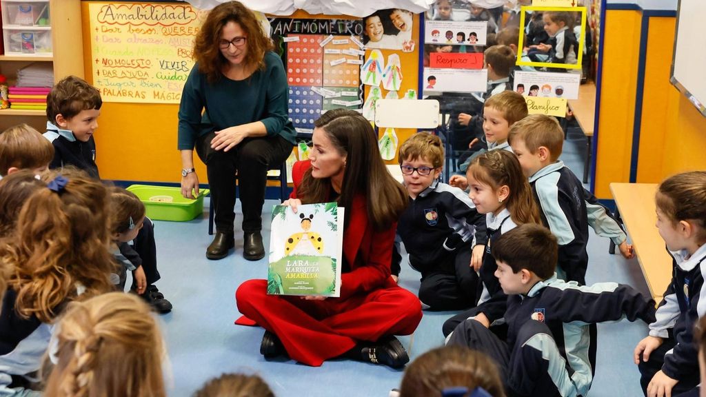 La reina Letizia, profesora por un día: en el suelo y contando cuentos en un colegio